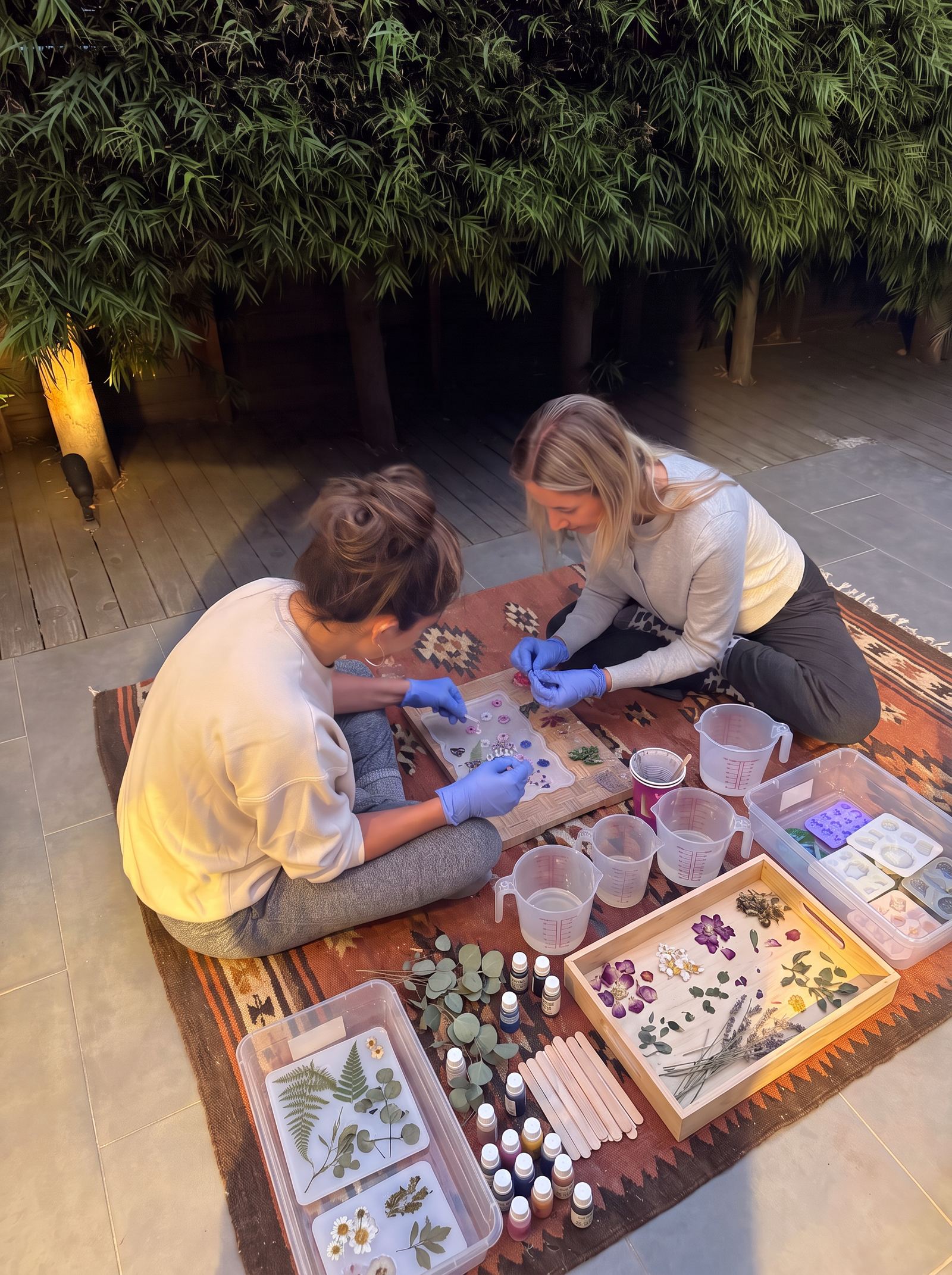 The two of us outside at dusk, arranging pressed flowers in our moulds on the night of our very first pour